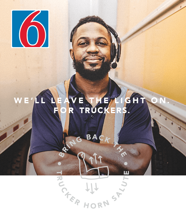 A picture of a man stabding with his arms crossed in front of two semi trailers. The copy reads 'We'll leave the light on. For truckers.'